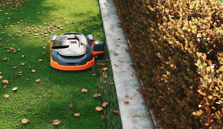 Navimow mower mowing in the fall with leaves on the ground